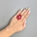 Anel feminino glamouroso com cristais vermelhos e base dourada para festa